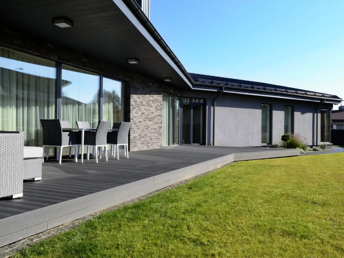 Terrasse i grå trekompositt langs en moderne enebolig