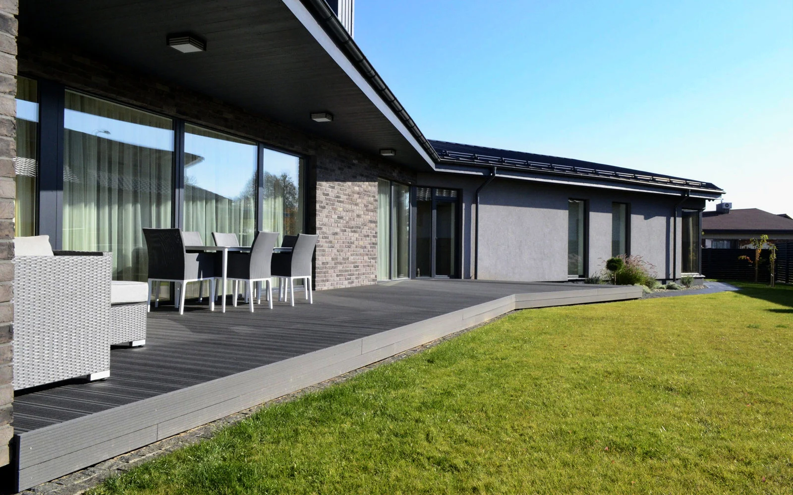 Terrasse i grå trekompositt langs en moderne enebolig
